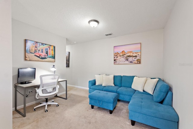 carpeted home office featuring a textured ceiling