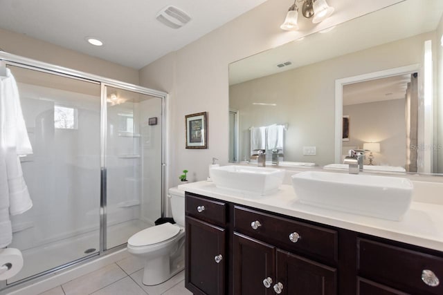 bathroom featuring walk in shower, tile floors, toilet, and dual bowl vanity