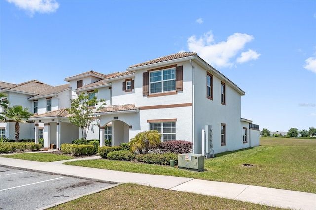 mediterranean / spanish home with central AC and a front yard