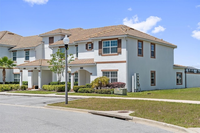 mediterranean / spanish house with a front lawn