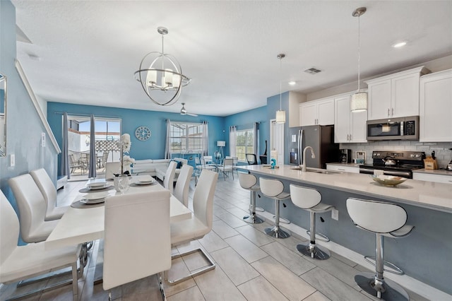 dining room with sink, an inviting chandelier, and light tile floors