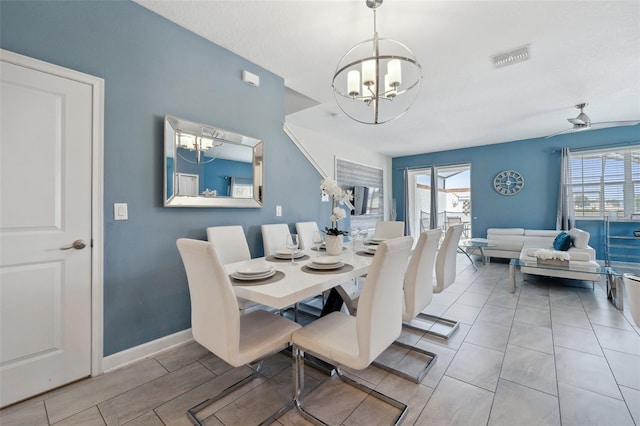 dining space featuring light tile flooring and ceiling fan with notable chandelier