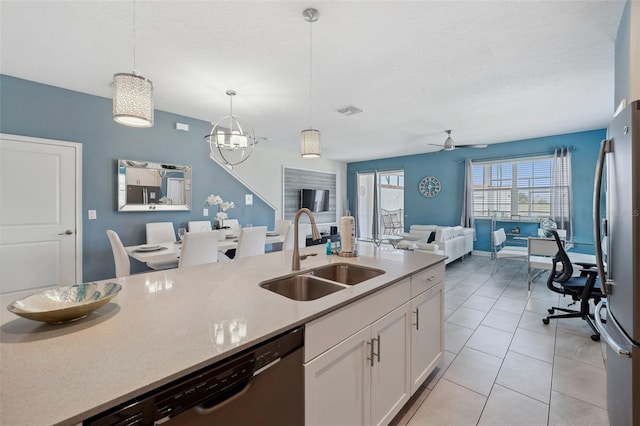 kitchen with appliances with stainless steel finishes, hanging light fixtures, ceiling fan with notable chandelier, sink, and white cabinets