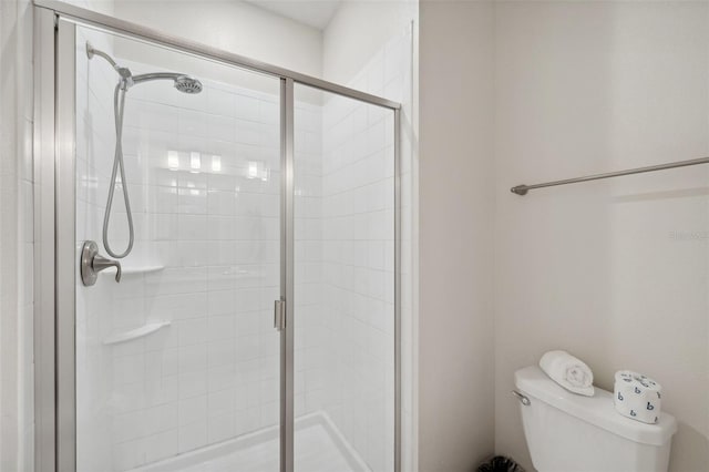 bathroom with toilet and a shower with door