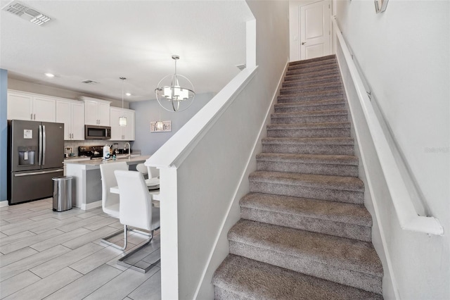 stairs with a chandelier and light tile floors