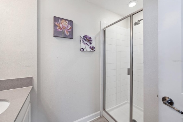 bathroom featuring vanity and a shower with door