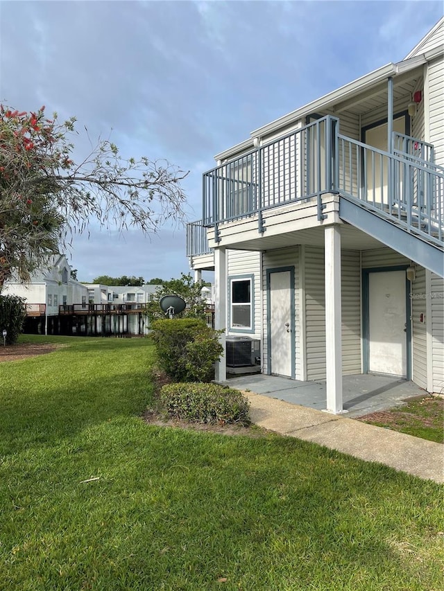 view of home's exterior featuring a balcony and a lawn