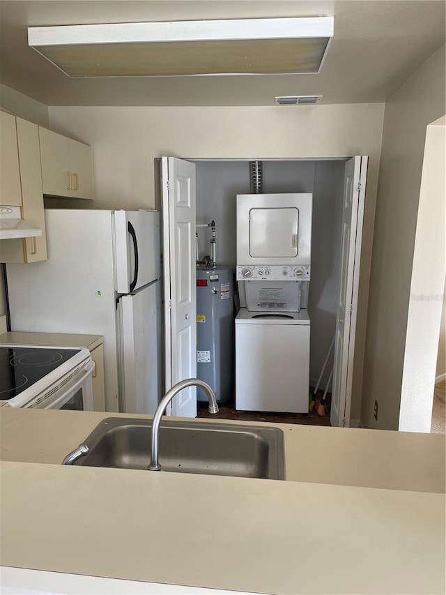 kitchen with sink, stacked washer / drying machine, white range with electric stovetop, and electric water heater