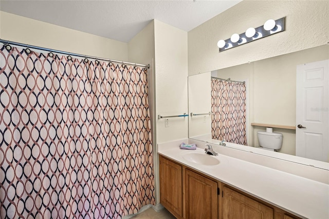 bathroom featuring toilet, vanity, and a textured ceiling