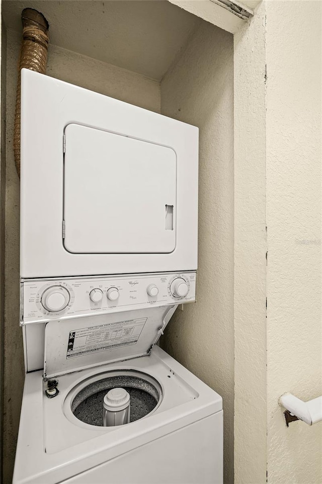 washroom with stacked washing maching and dryer