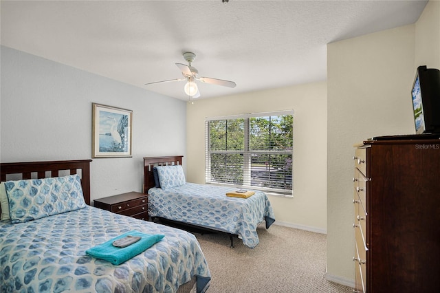 carpeted bedroom featuring a textured ceiling and ceiling fan