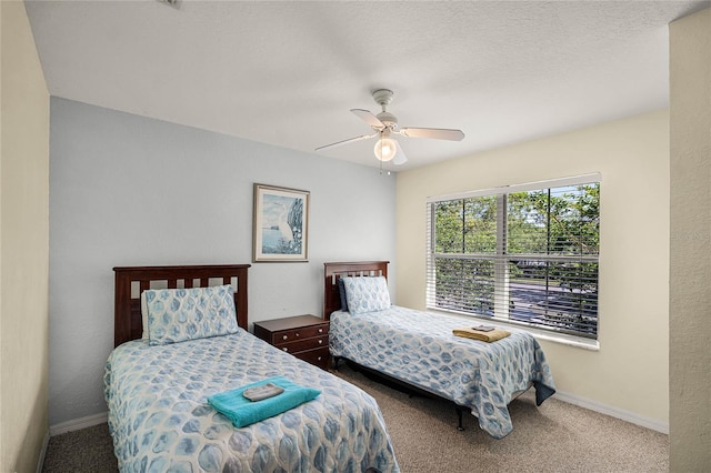 bedroom with ceiling fan, carpet floors, and a textured ceiling