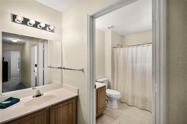 bathroom with tile flooring, vanity with extensive cabinet space, and toilet