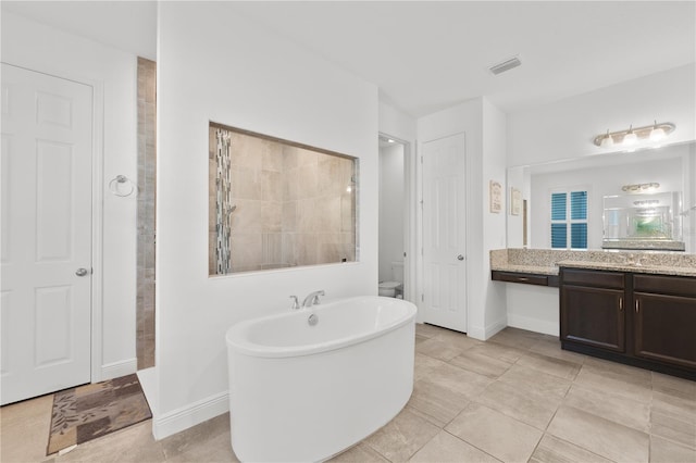 bathroom featuring a washtub, tile floors, and vanity