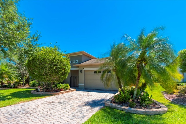 obstructed view of property with a garage and a front lawn