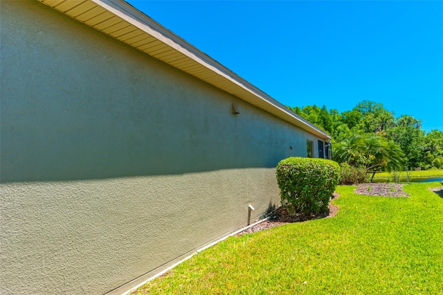 view of side of home with a yard