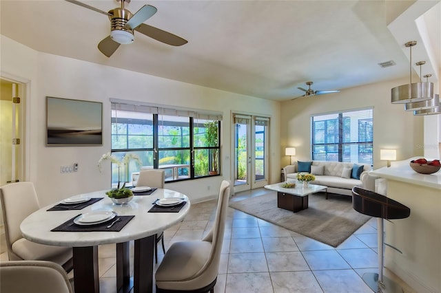 tiled dining space featuring french doors and ceiling fan