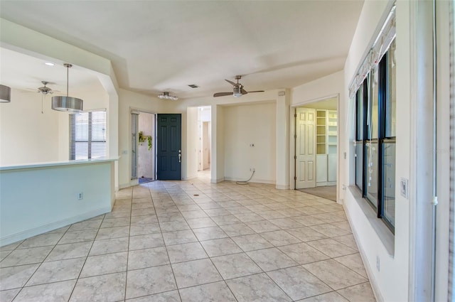 unfurnished room with ceiling fan and light tile floors