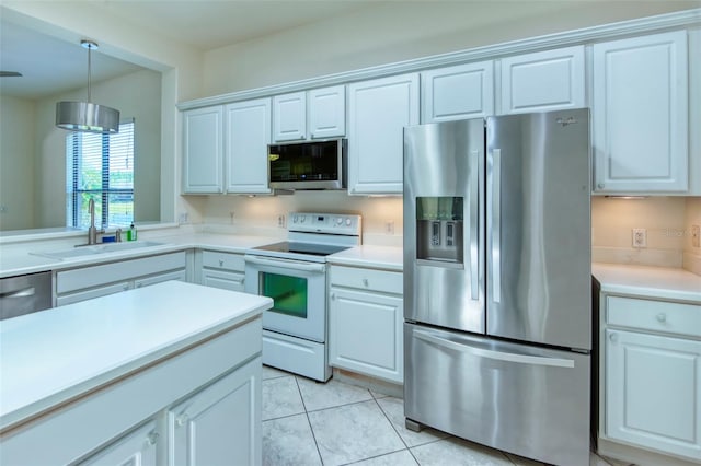 kitchen featuring appliances with stainless steel finishes, white cabinets, decorative light fixtures, sink, and light tile floors