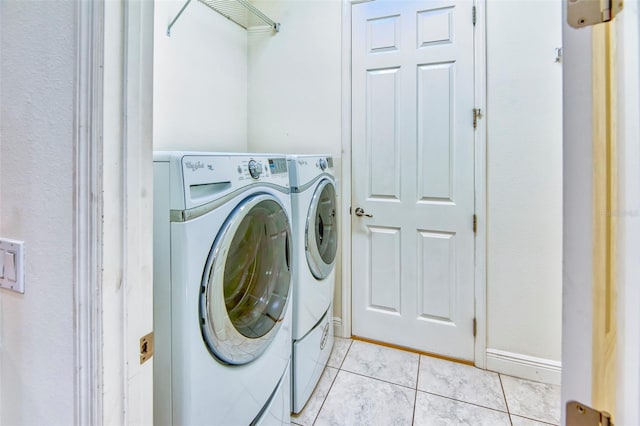 laundry area with washing machine and dryer and light tile floors