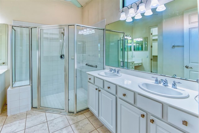 bathroom featuring double vanity, tile floors, and a shower with door