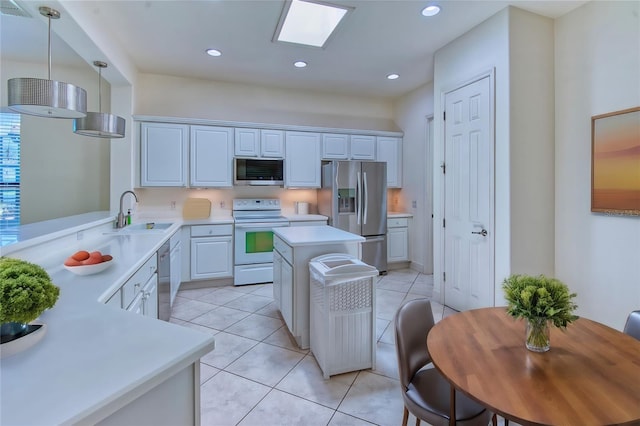 kitchen with a kitchen island, appliances with stainless steel finishes, pendant lighting, sink, and light tile floors