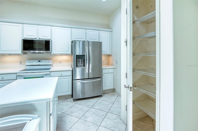 kitchen with light tile floors, white cabinetry, and appliances with stainless steel finishes