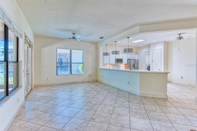 kitchen with pendant lighting, light tile flooring, ceiling fan, and stainless steel appliances