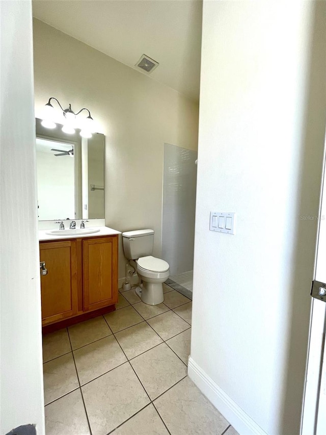 bathroom featuring tile flooring, toilet, and vanity