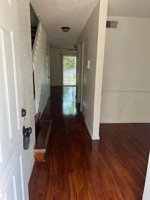 hall featuring dark hardwood / wood-style flooring and a textured ceiling