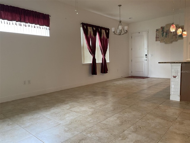 2410 Datura Loop, Saint Cloud, FL 34772 - spare room featuring a chandelier, light tile patterned floors, and baseboards
