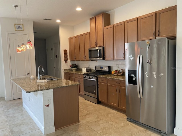 2410 Datura Loop, Saint Cloud, FL 34772 - kitchen featuring appliances with stainless steel finishes, a sink, decorative backsplash, dark stone countertops, and light tile patterned flooring