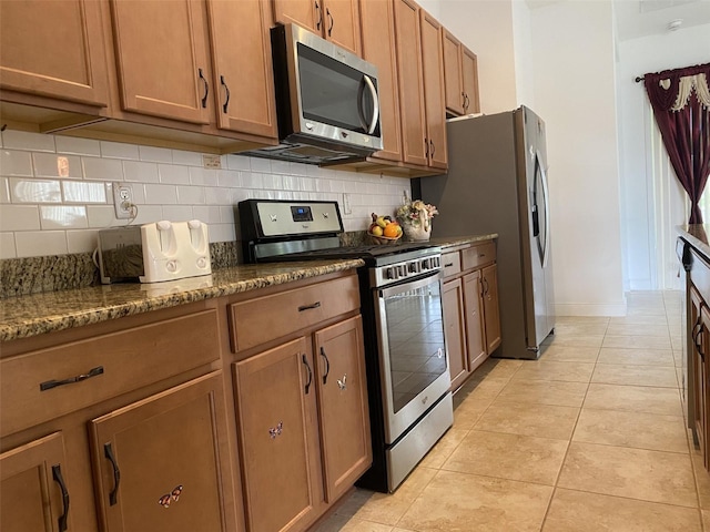 2410 Datura Loop, Saint Cloud, FL 34772 - kitchen featuring stainless steel appliances, tasteful backsplash, light tile patterned floors, and brown cabinetry