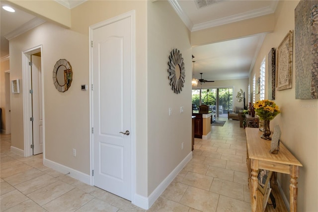 hallway with crown molding and light tile floors