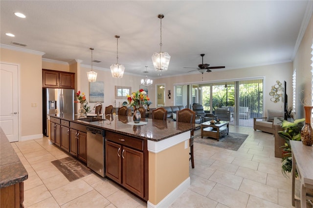 kitchen with a center island with sink, stainless steel appliances, sink, and a breakfast bar area