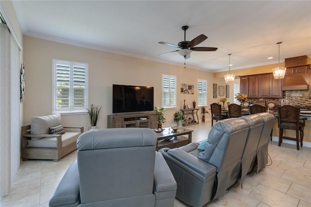 living room with crown molding, ceiling fan with notable chandelier, light tile floors, and a wealth of natural light