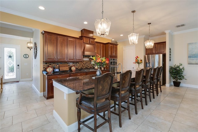 kitchen featuring backsplash, dark stone counters, a kitchen breakfast bar, premium range hood, and pendant lighting