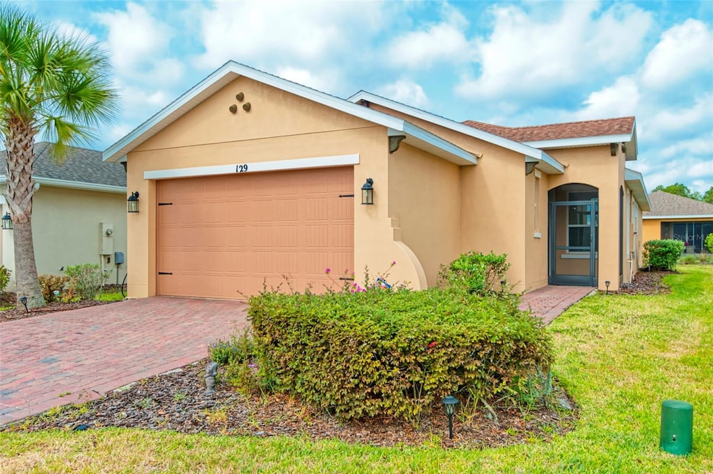 single story home featuring a garage and a front lawn