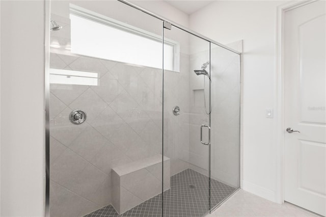 bathroom featuring a shower with door and tile floors