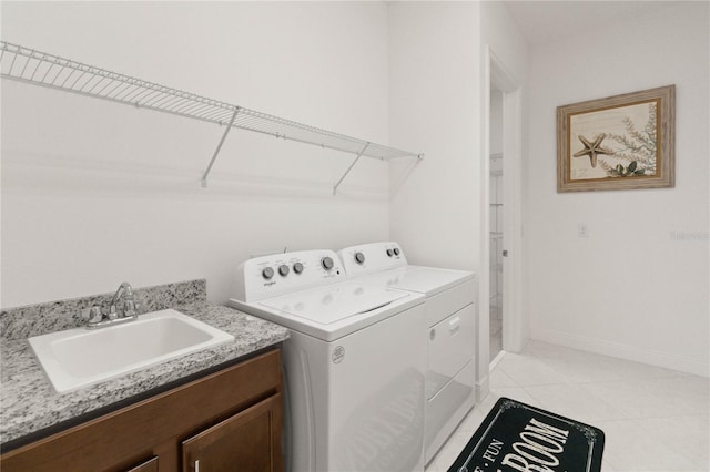 washroom with sink, independent washer and dryer, cabinets, and light tile flooring