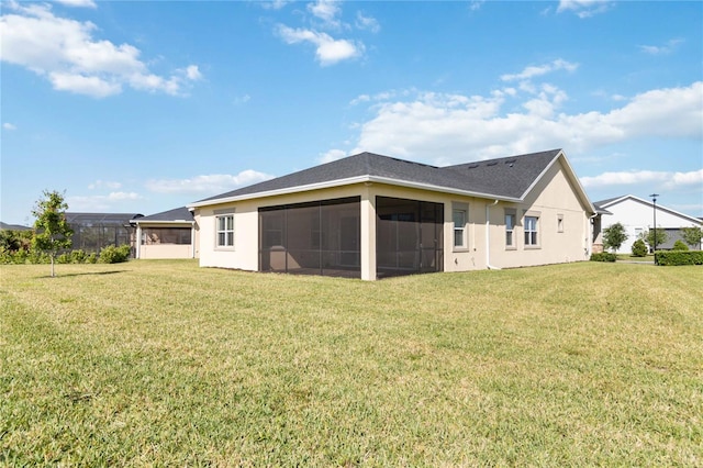 rear view of property with a yard and a sunroom