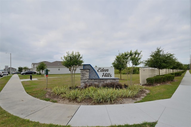 community / neighborhood sign featuring a yard