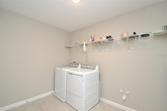 laundry area featuring light tile patterned floors and washing machine and clothes dryer