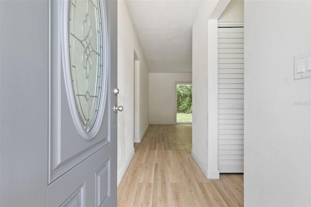 entryway with light hardwood / wood-style flooring and a textured ceiling