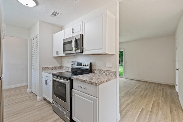 kitchen with light wood-type flooring, white cabinetry, stainless steel appliances, and light stone counters