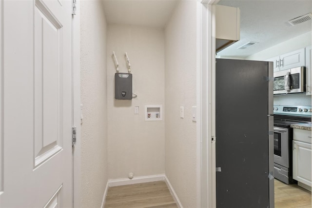 laundry area featuring light wood-type flooring and washer hookup