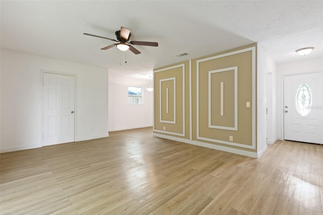 foyer entrance featuring light hardwood / wood-style flooring, ceiling fan, and a textured ceiling