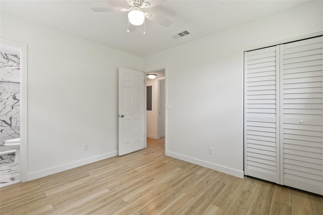 unfurnished bedroom with connected bathroom, ceiling fan, a closet, and light hardwood / wood-style flooring