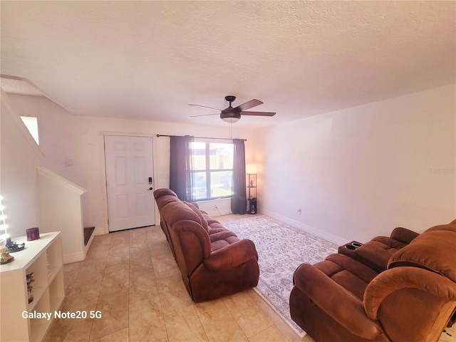 tiled living room with a textured ceiling and ceiling fan