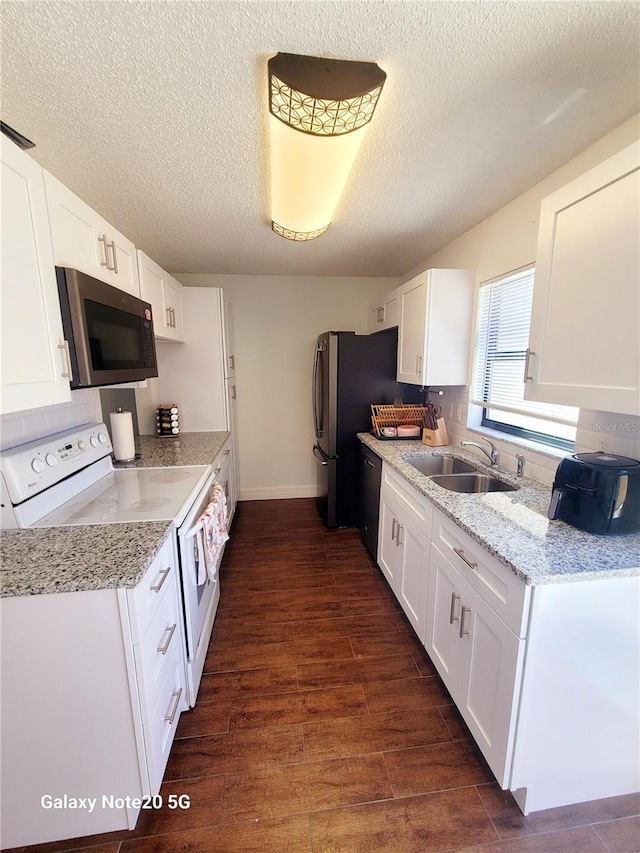 kitchen featuring stainless steel microwave, electric range, dark hardwood / wood-style floors, white cabinetry, and sink